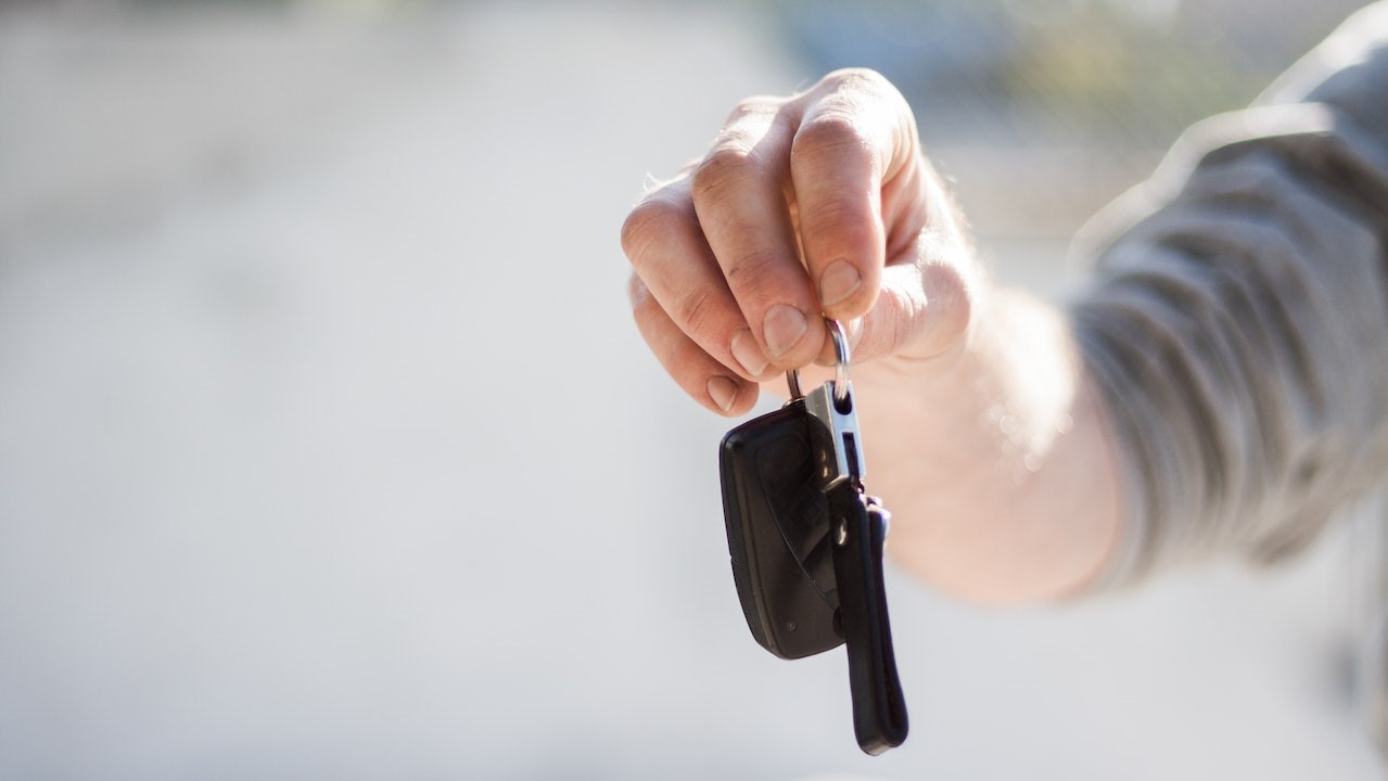 Grey Shirt Handing Keys | Goodwill Car Donations