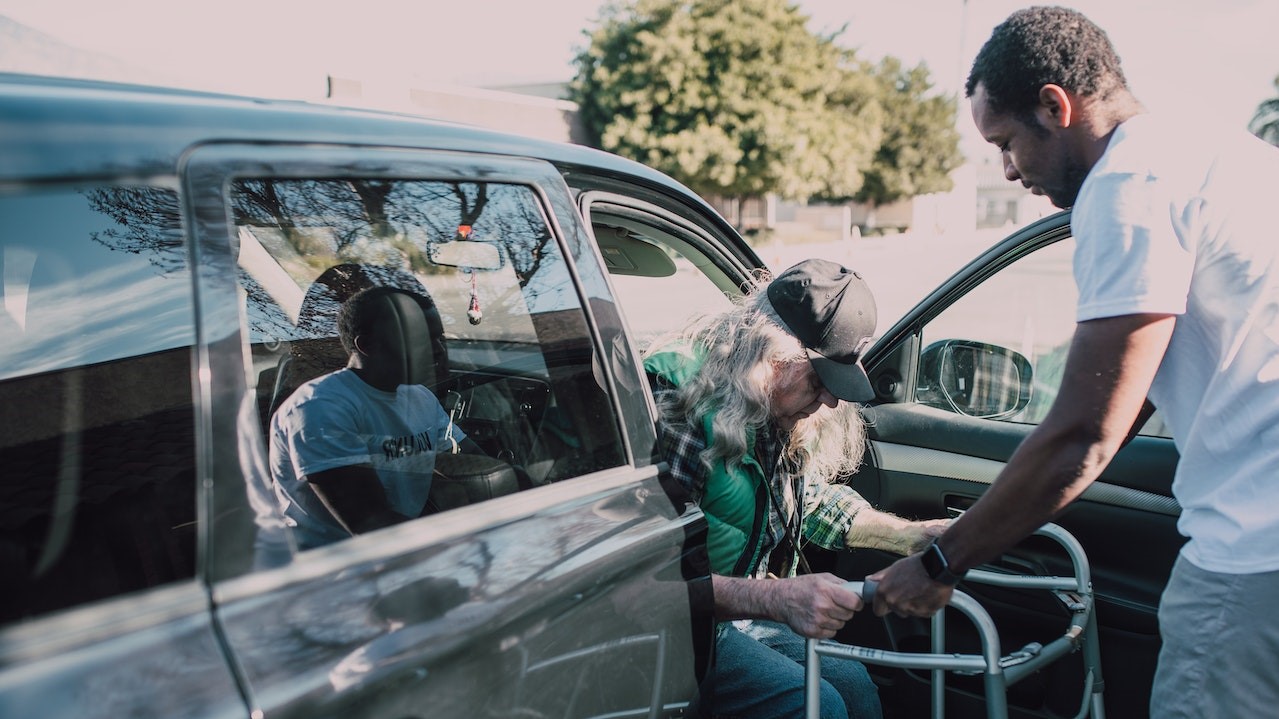 Man in White Shirt Helping an Elderly Person | Goodwill Car Donations