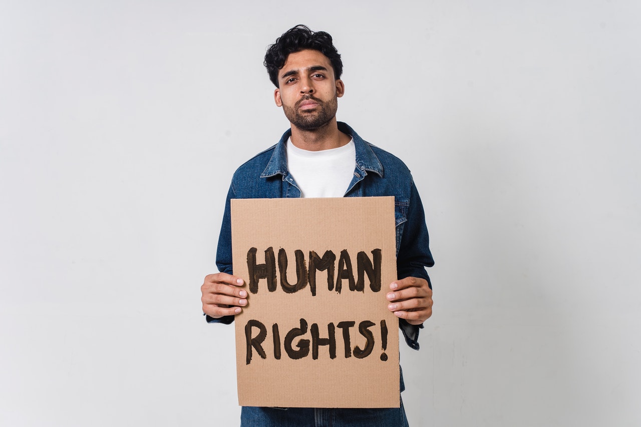 Person Holding Human Rights Banner | Goodwill Car Donations
