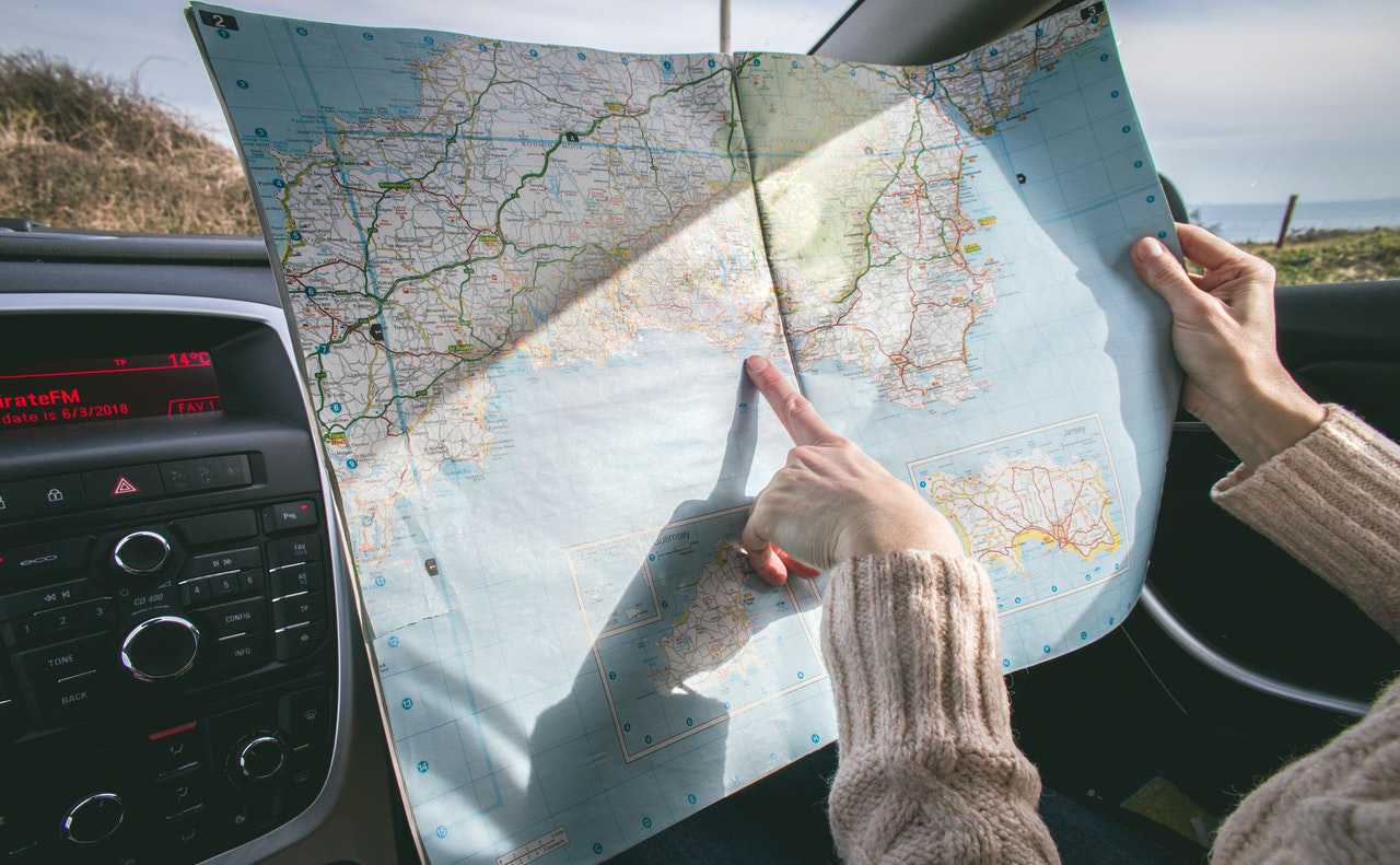 Person Holding a Map While Traveling | Goodwill Car Donations