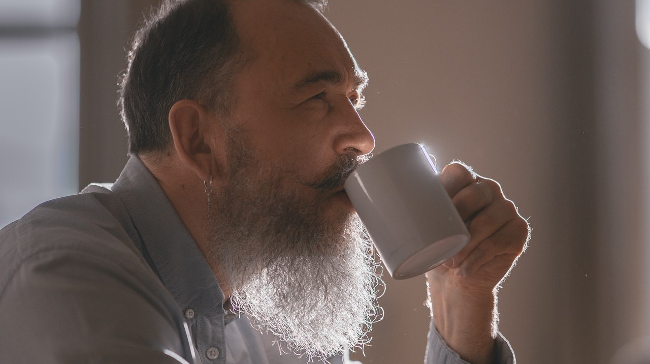 Old Man Taking a Sip of Coffee | Goodwill Car Donations