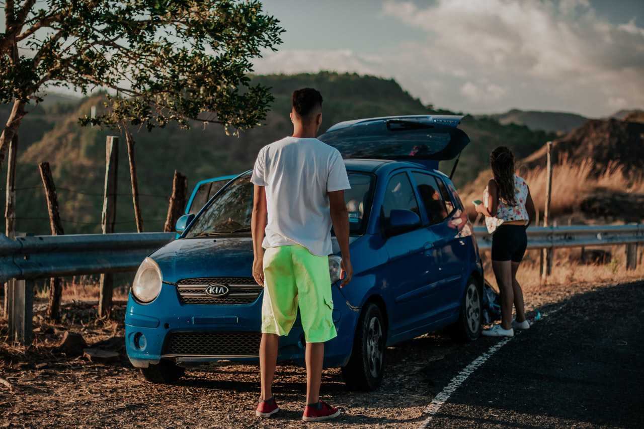 People with Blue Car Parked Beside a Street | Goodwill Car Donations