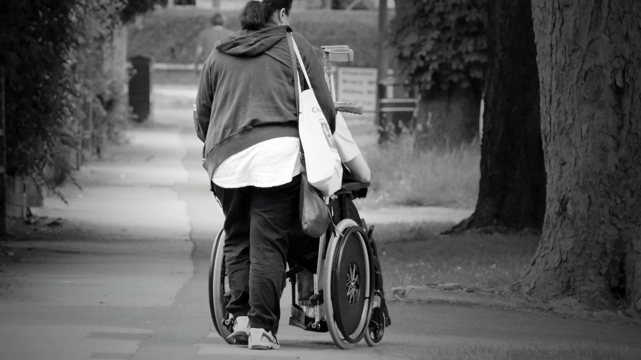 Woman pushing a wheelchair | Goodwill Car Donations