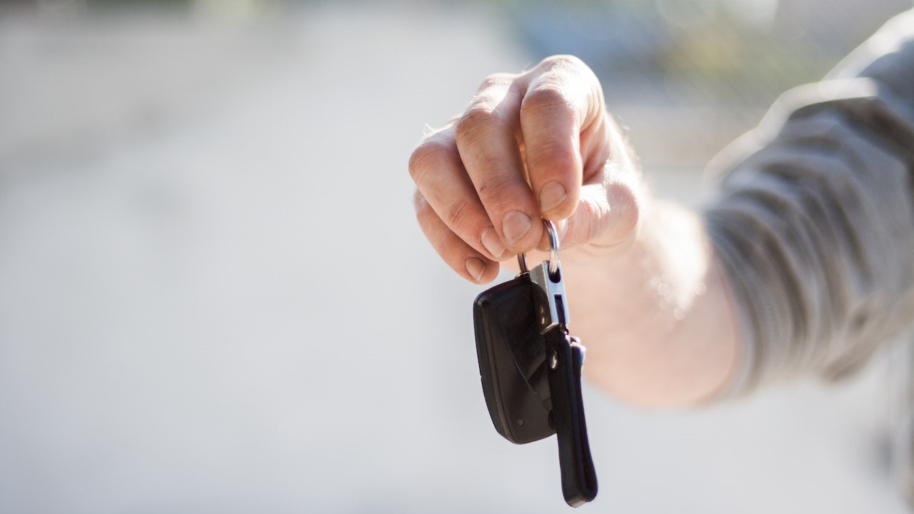 Person in Grey Shirt Handing Keys | Goodwill Car Donations