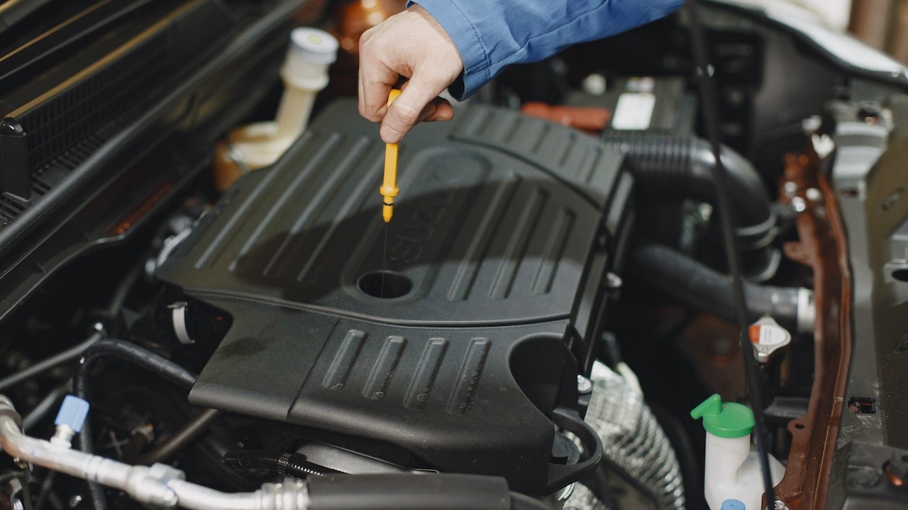 Person Checking the Oil of an Engine | Goodwill Car Donations