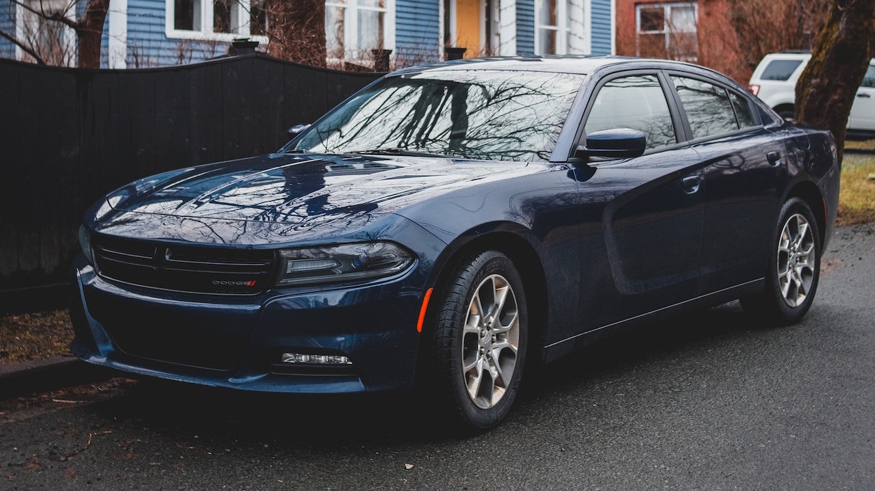 car parked near fence of residential building | Goodwill Car Donations