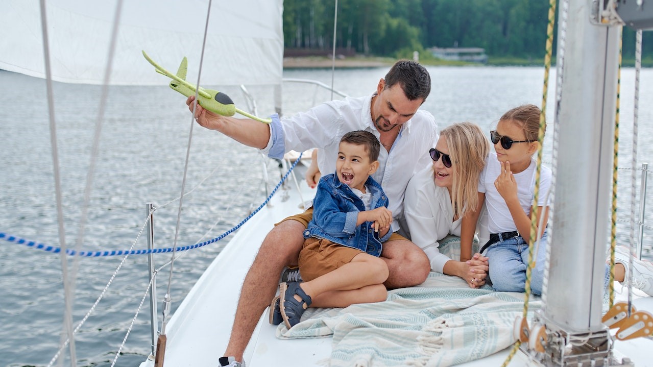 Happy family on sailboat in sea | Goodwill Car Donations