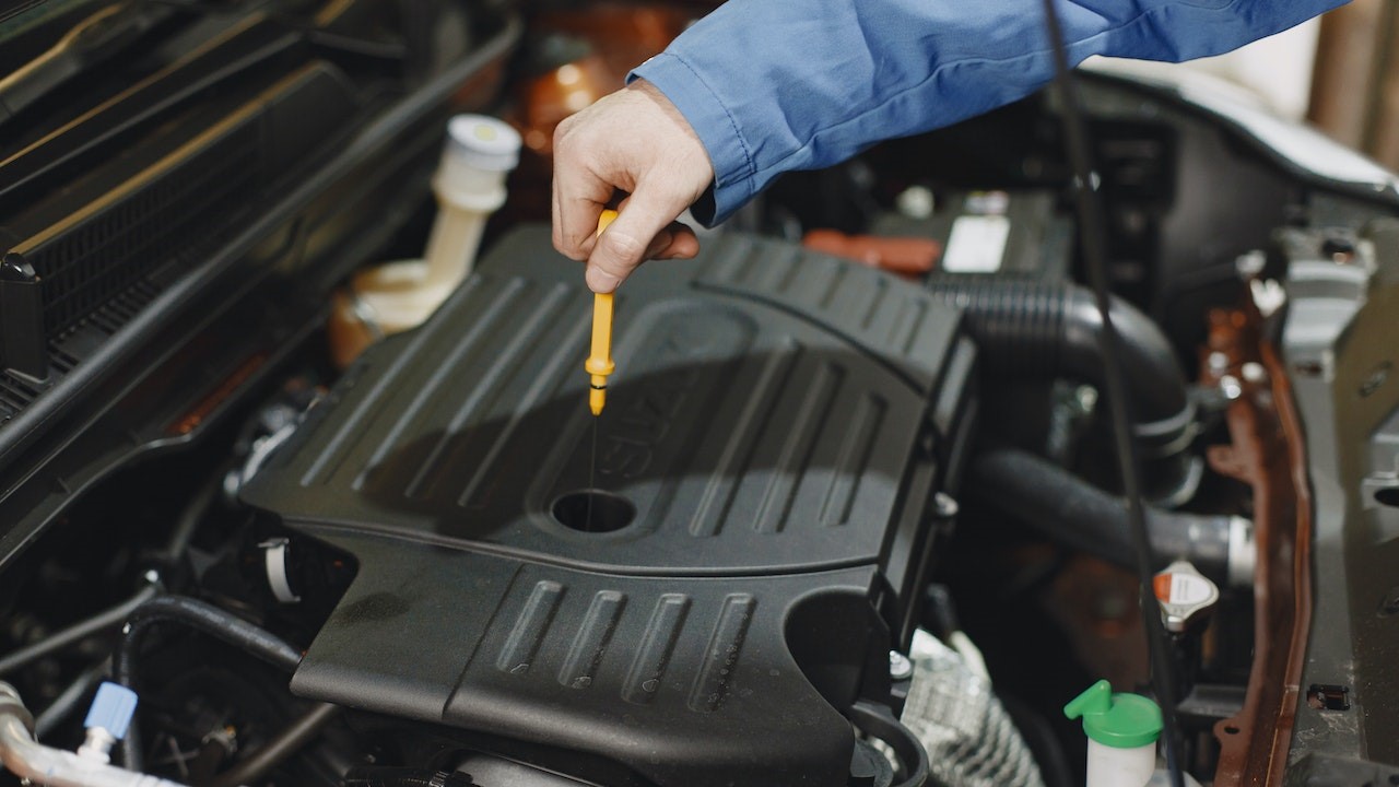 Person Checking the Oil of an Engine | Goodwill Car Donations