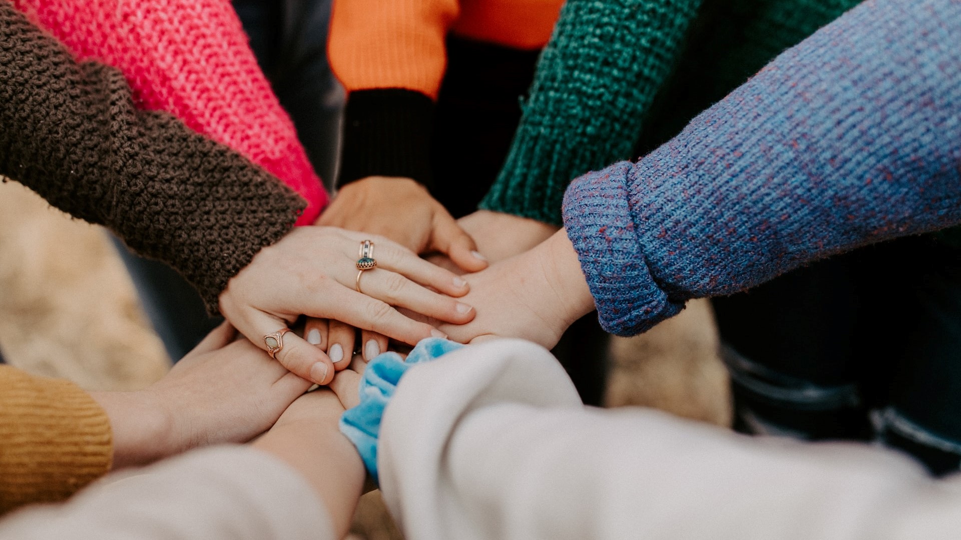 People stacking their hand in huddle | Goodwill Car Donations