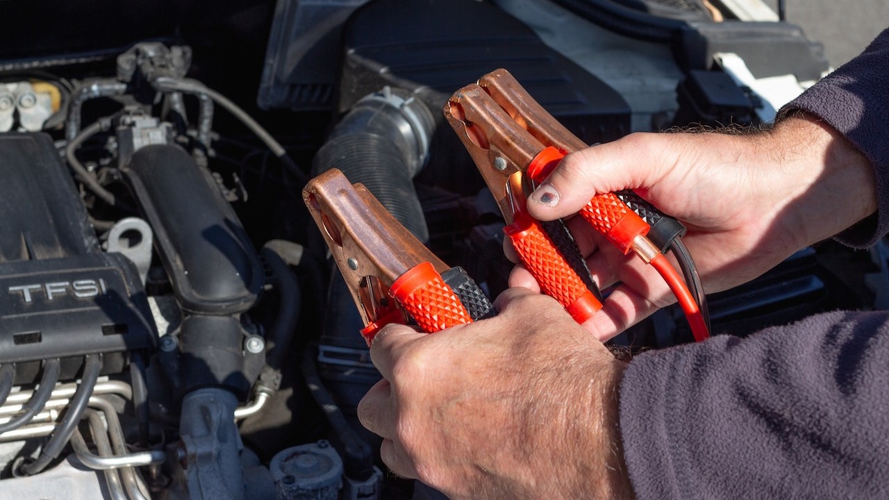Person holding a battery jumper clamp | Goodwill Car Donations