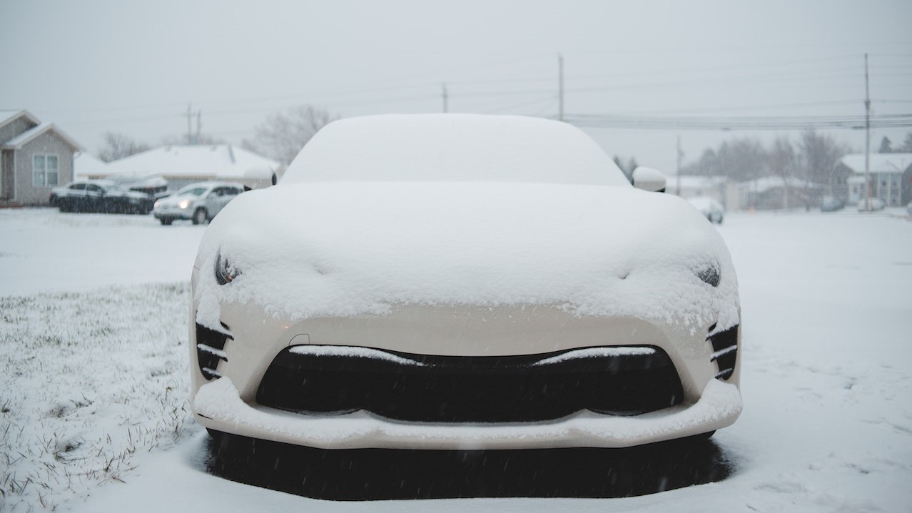 Car covered with snow parked in town | Goodwill Car Donations