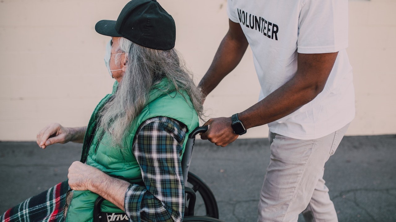 Man helping man on wheelchair | Goodwill Car Donations