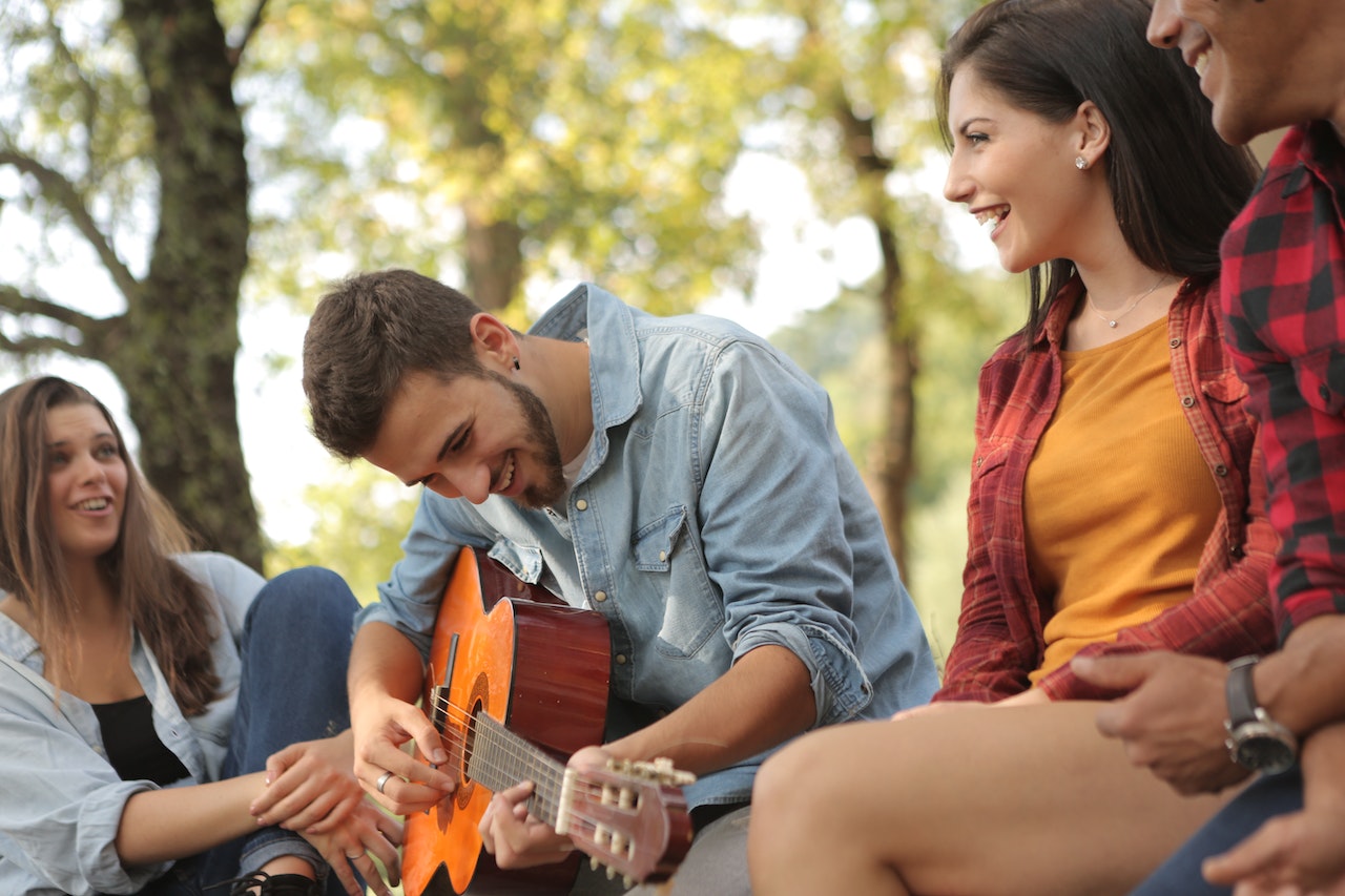 Friends spending time together with guitar | Goodwill Car Donations