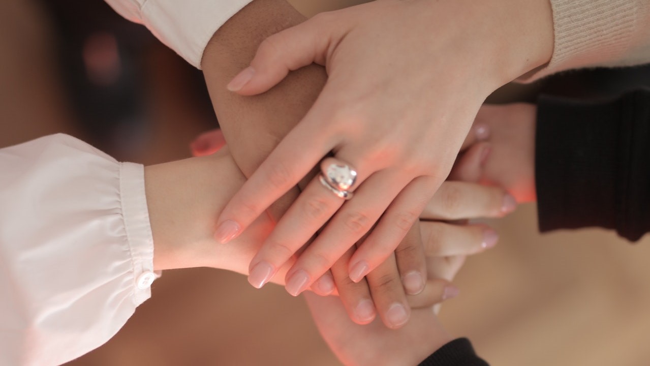 Crop friends stacking hands together  | Goodwill Car Donations