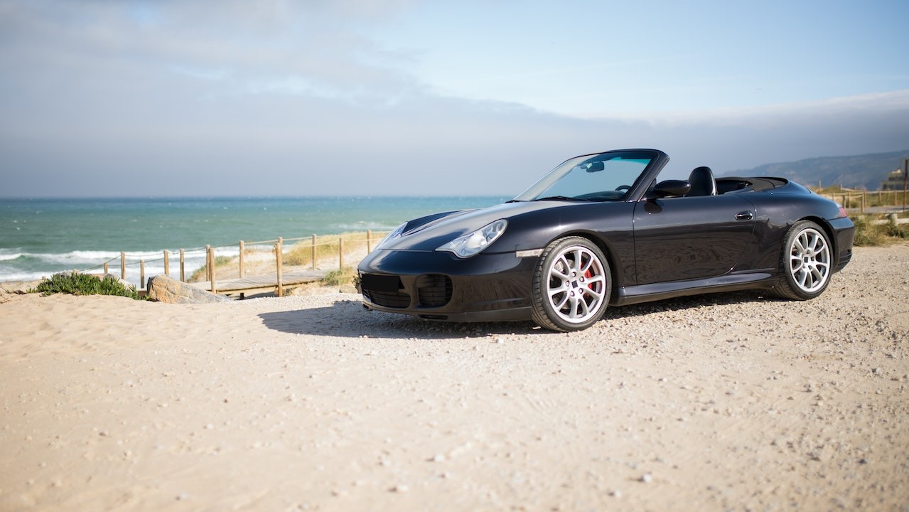 Black car parked on beach | Goodwill Car Donations