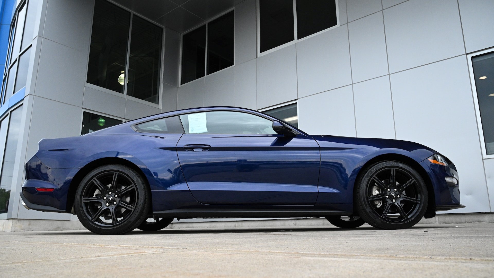 Blue coupe parked near building | Goodwill Car Donations