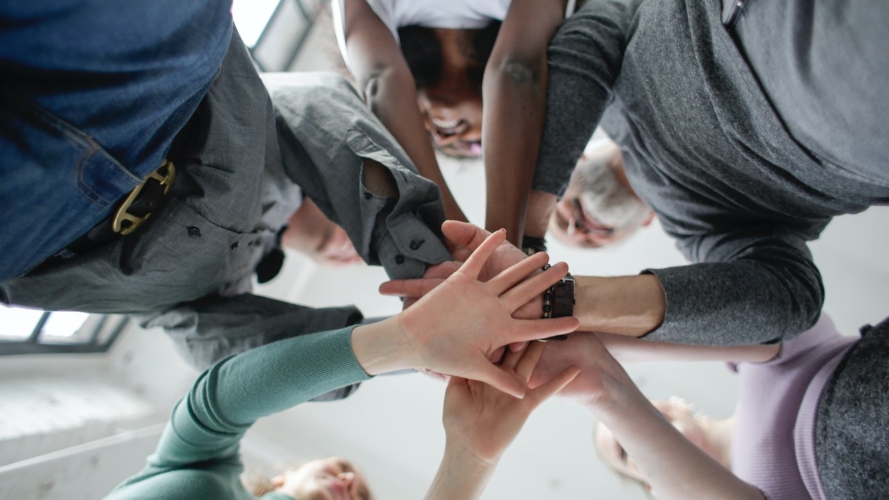 Low angle Photo of People Holding Hands Together | Goodwill Car Donations