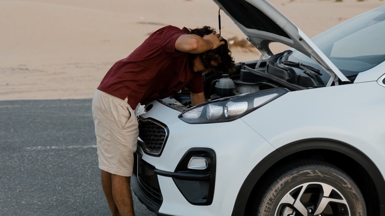 Man fixing his car on the road | Goodwill Car Donations