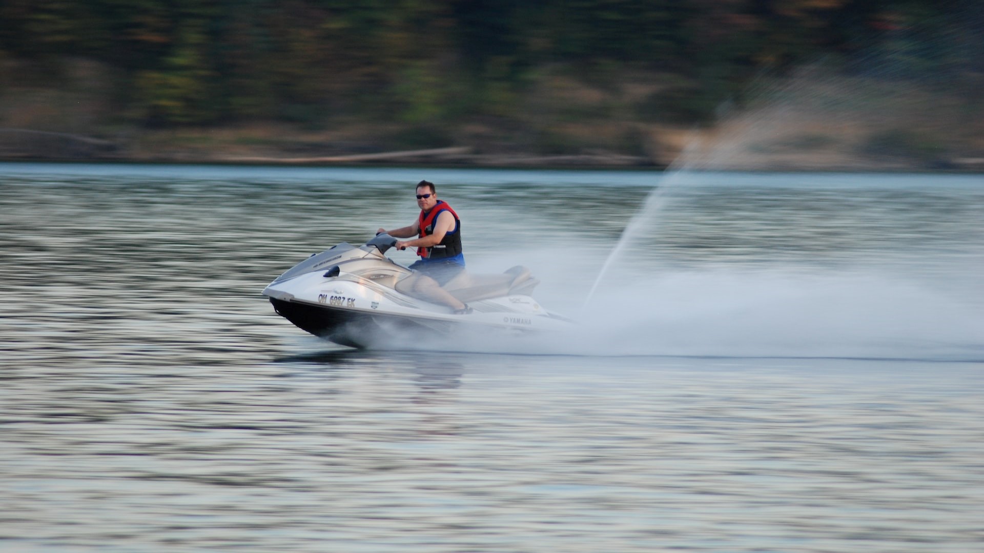 Man wearing a red vest riding a jetski | Goodwill Car Donations