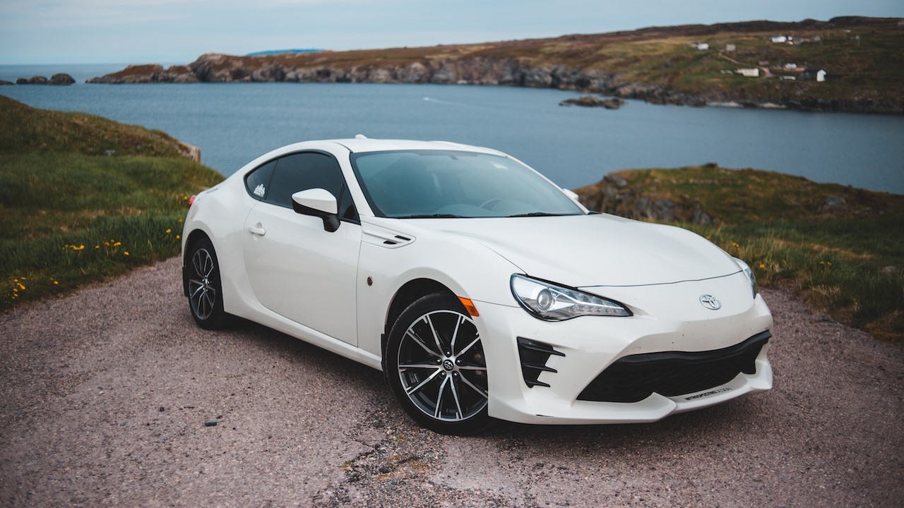 Modern white car parked on picturesque lake shore | Goodwill Car Donations