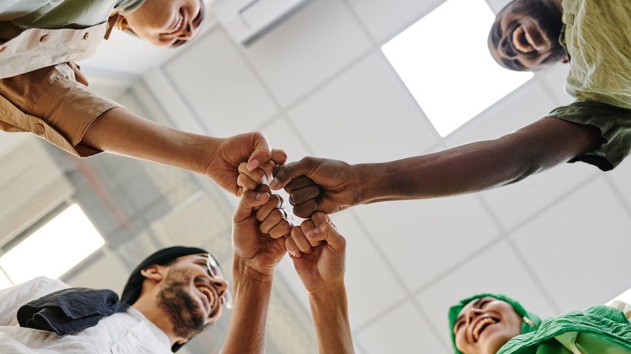 Office Team Huddling in the Room | Goodwill Car Donations