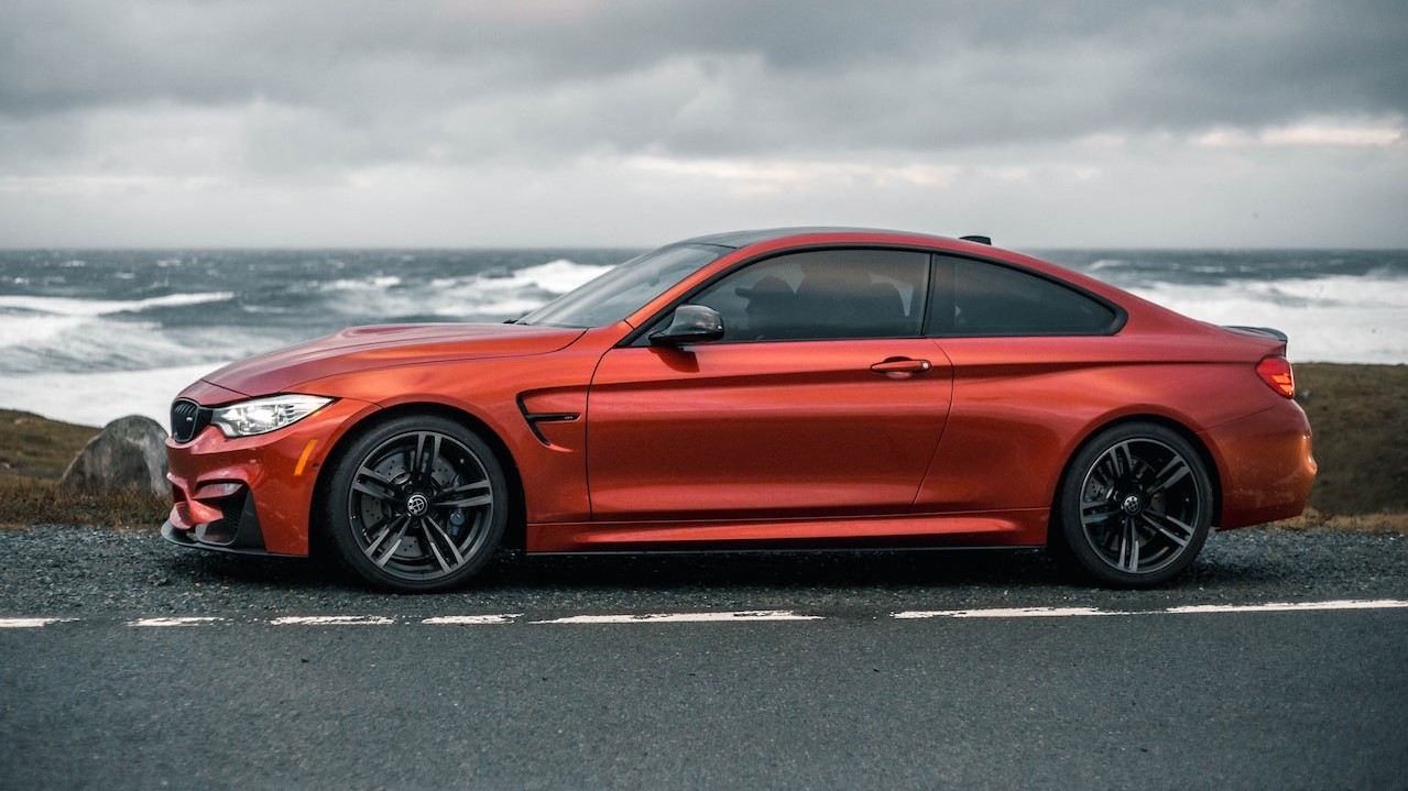 Orange Car on Gray Asphalt Road Under Gray Cloudy Sky | Goodwill Car Donations