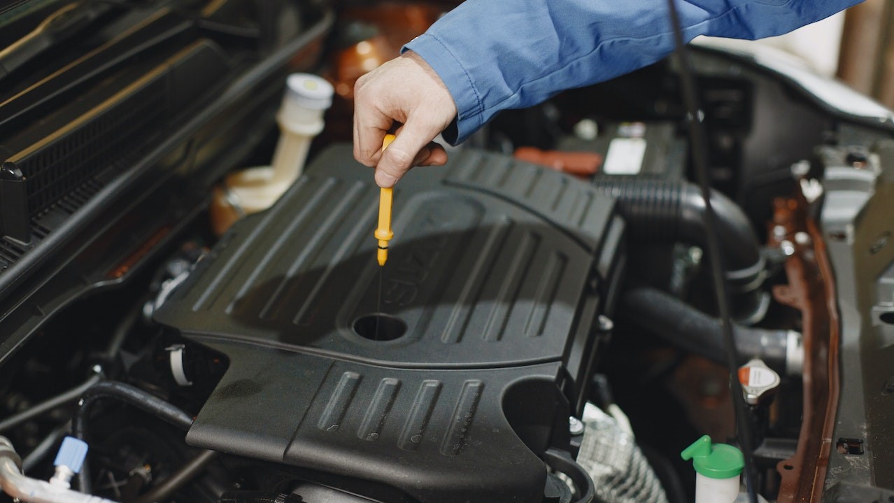 Person Checking the Oil of an Engine | Goodwill Car Donations