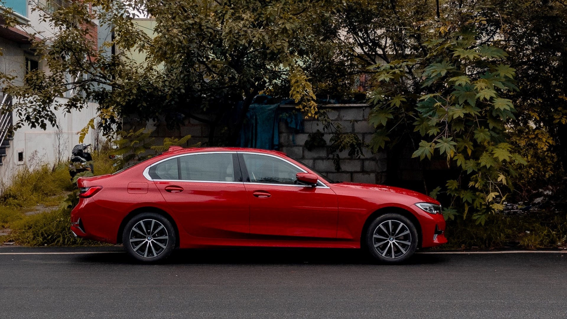 Red Sedan car parked near tree | Goodwill Car Donations