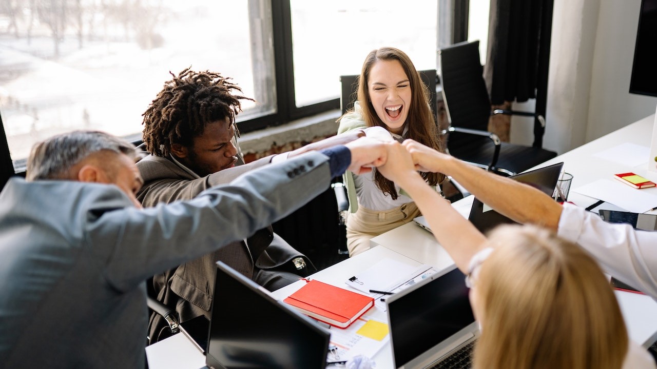 Triumphant Colleagues doinga Fist Bump | Goodwill Car Donations