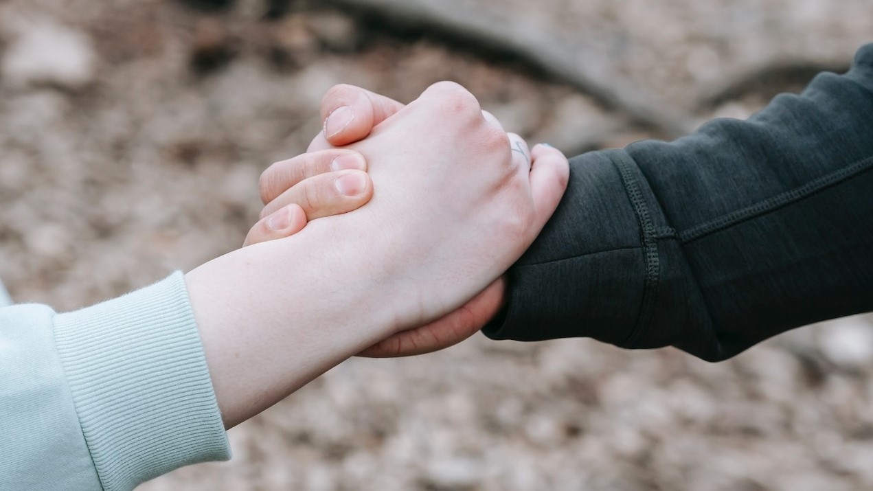 Two hand holding in forest | Goodwill Car Donations