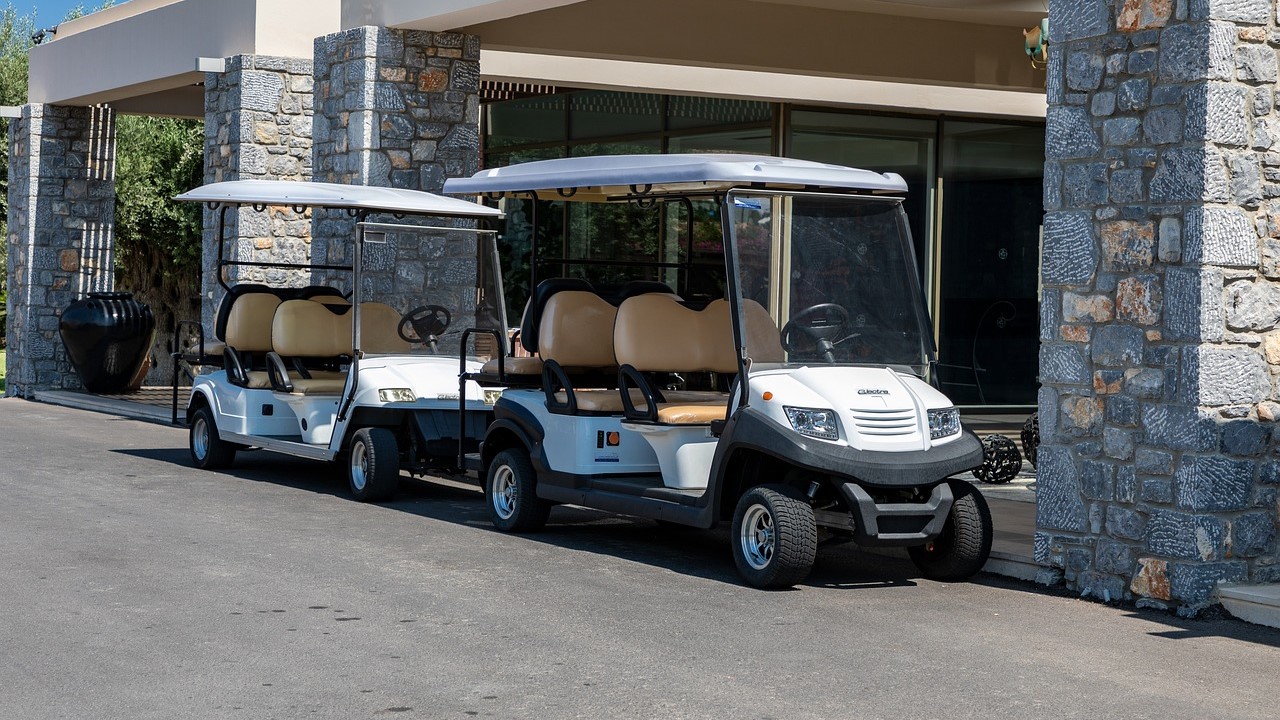 Two white golf carts parked | Goodwill Car Donations