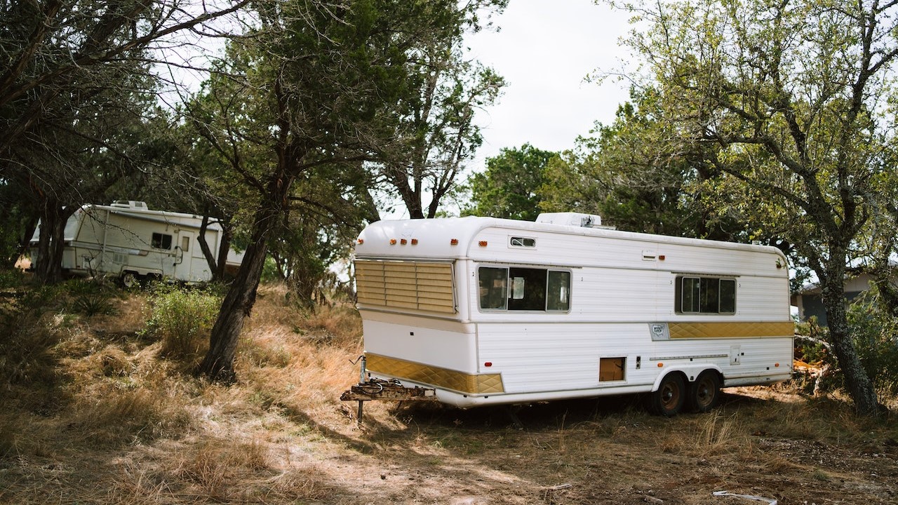 White trailer parked in the forest | Goodwill Car Donations