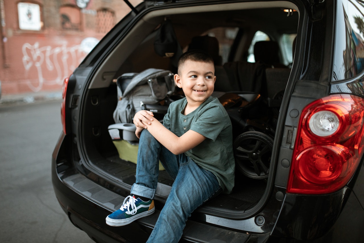 A Boy Sitting in a Car Looking Over His Shoulder | Goodwill Car Donations
