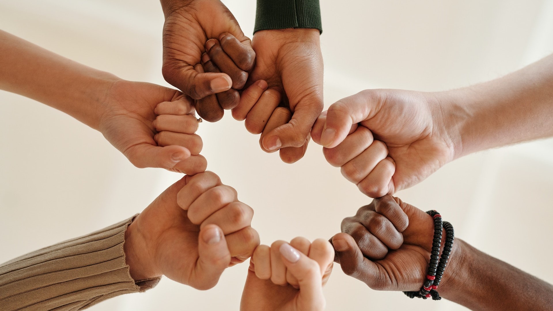 Close-up of People Bumping Fists | Goodwill Car Donations