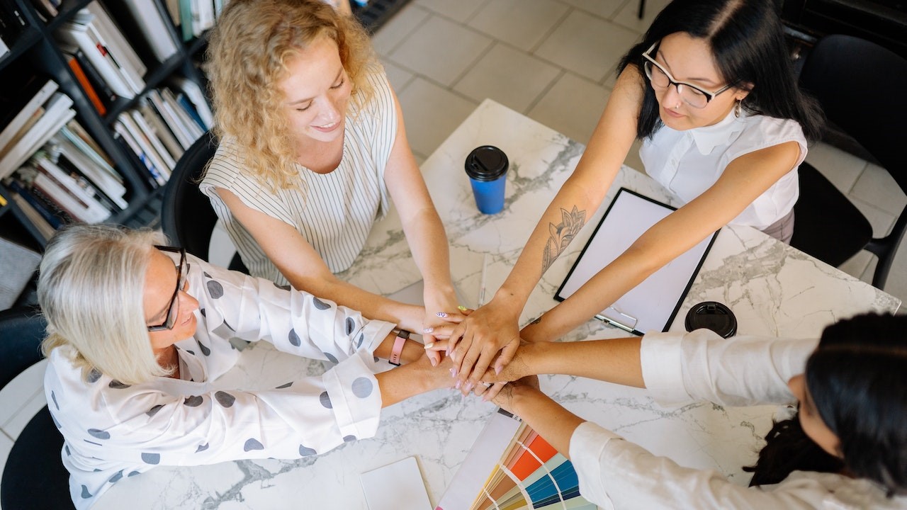 Hands Together of Women Sitting at Marbled Table | Goodwill Car Donations