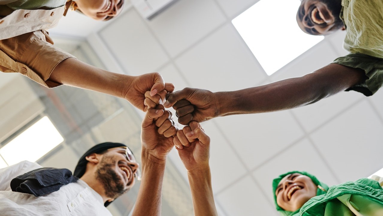 Office Team Huddling in the Room | Goodwill Car Donations