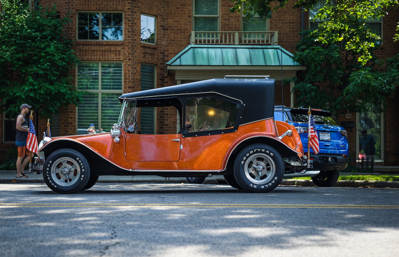 Orange and Black Vintage Car Parked on Gray Asphalt Road | Goodwill Car Donations