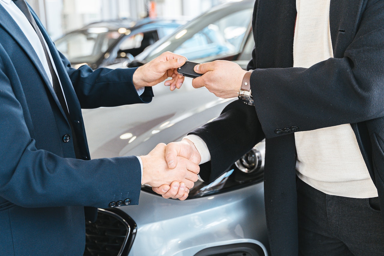 Person Giving a Car Key To Another Person | Goodwill Car Donations