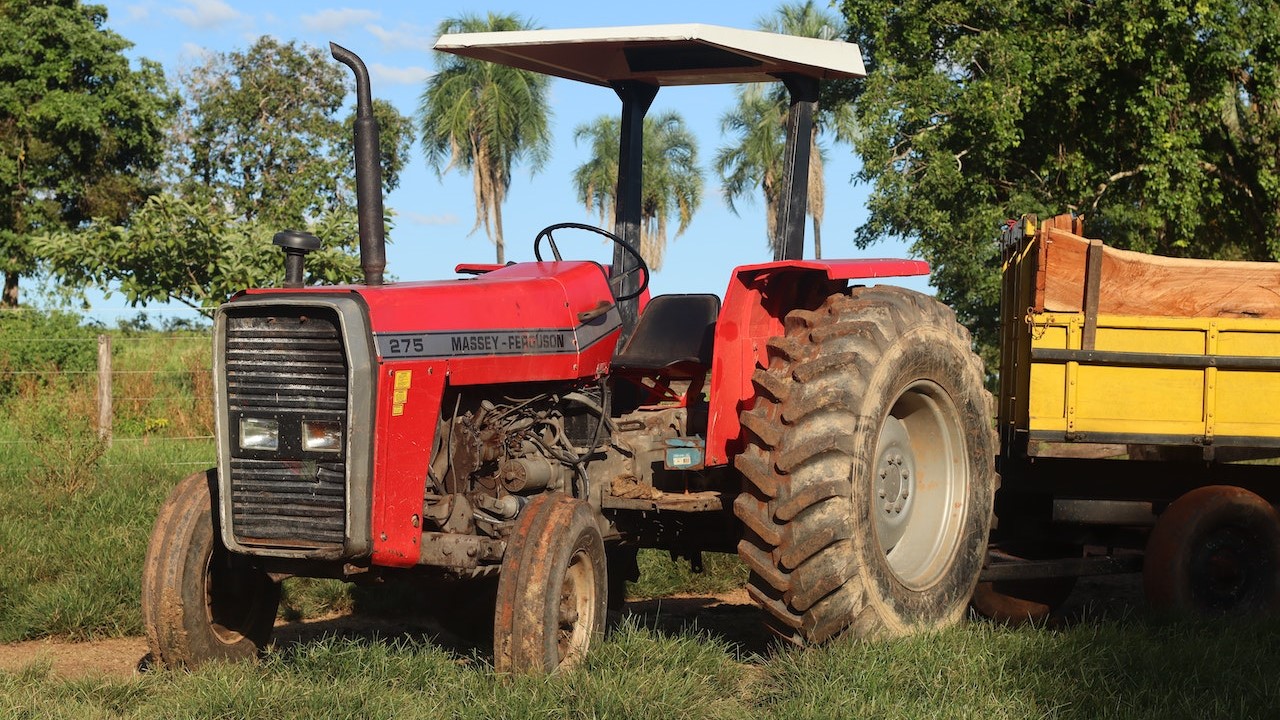 Red Tractor Parked on Green Grass | Goodwill Car Donations
