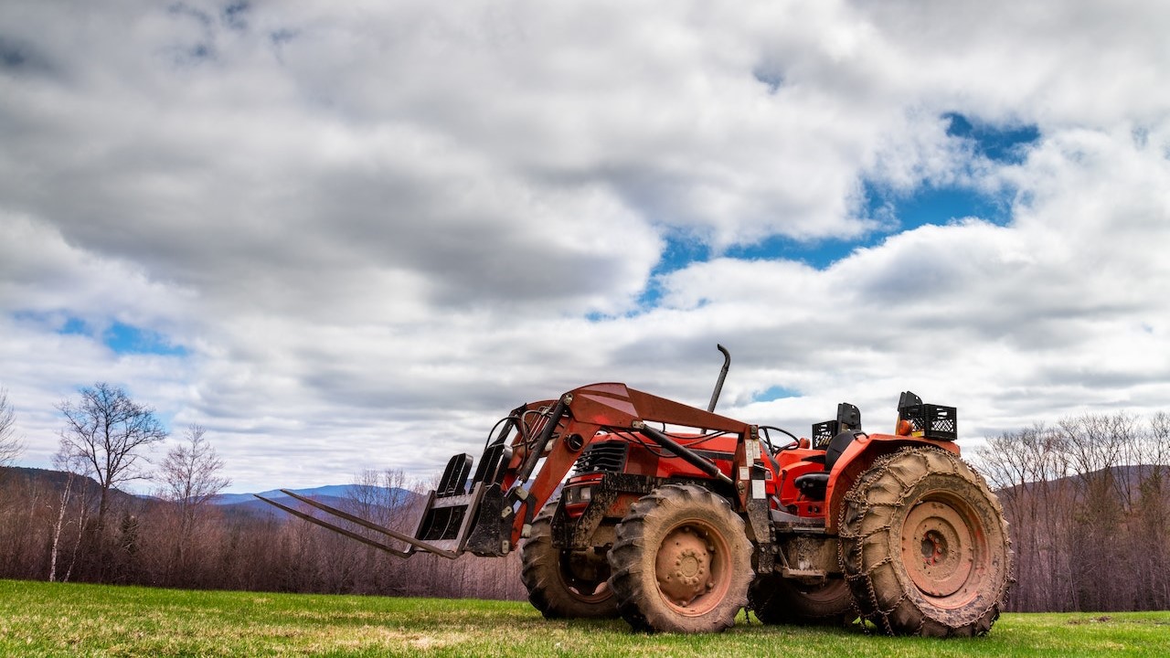 Tractor parked in farmland near leaflessGoodwill Car Donations trees |