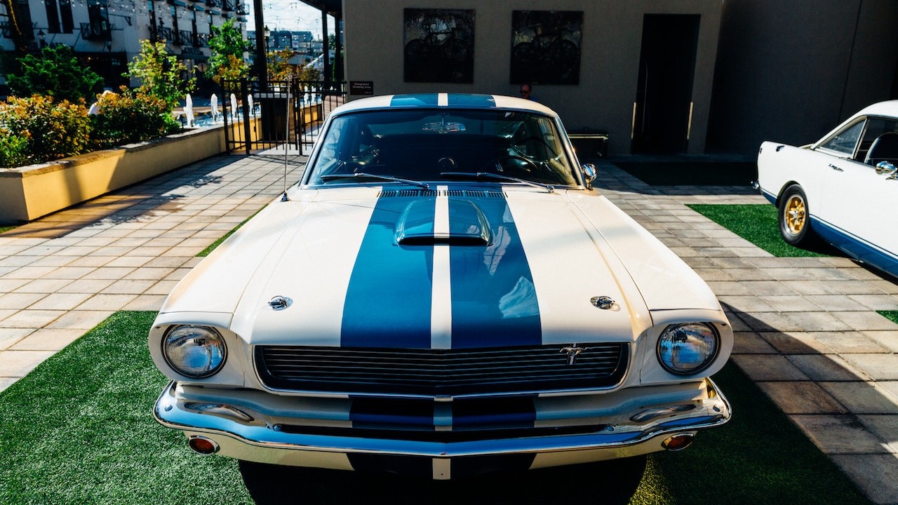 White with blue stripe coupe parked | Goodwill Car Donations