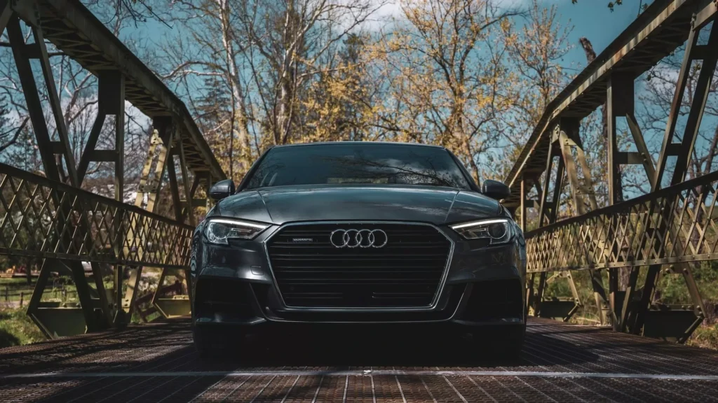 A black car is parked on a bridge