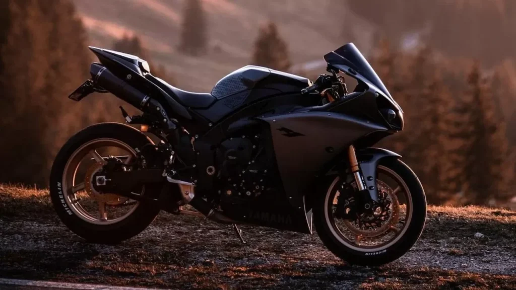 Black sports motorcycle parked on a scenic road during sunset with mountain views.