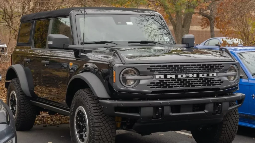 A modern black Ford Bronco SUV parked outdoors in a fall setting