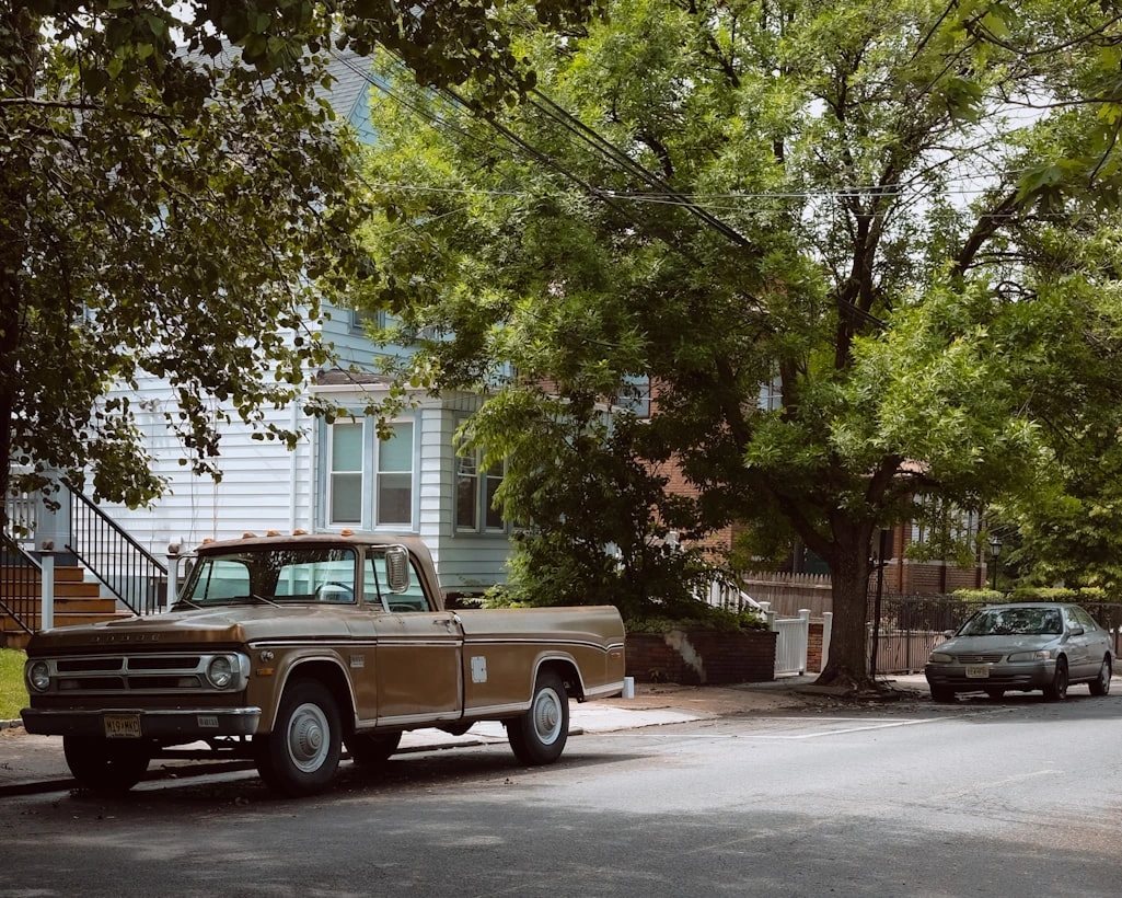 A brown truck parked on the side of a road