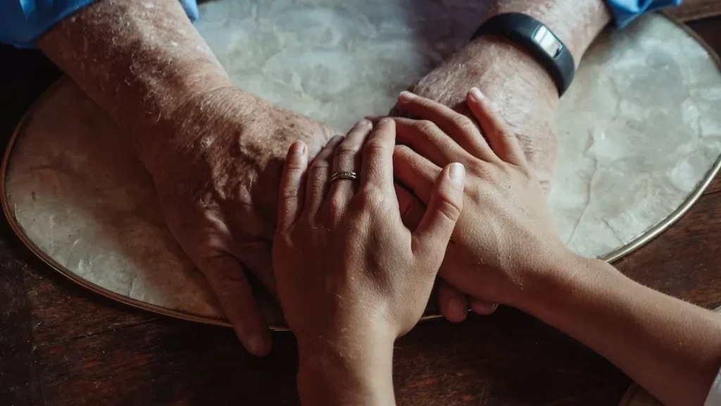 Close-up of elderly and young hands joined, symbolizing compassion and support