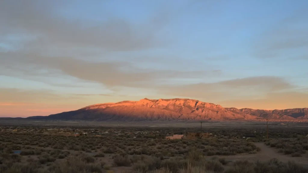 A desert landscape with a mountain in the background