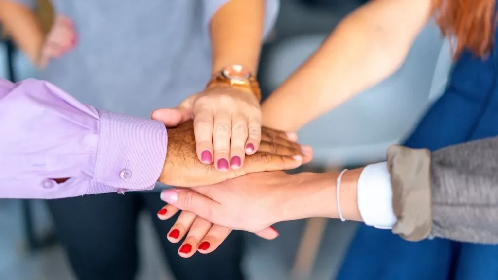 Close-up of diverse hands joined in a symbol of unity and teamwork