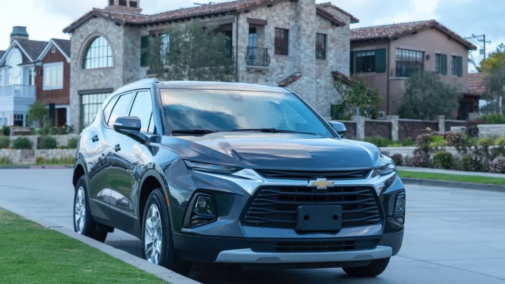 A silver chevrolet suv parked in front of a house
