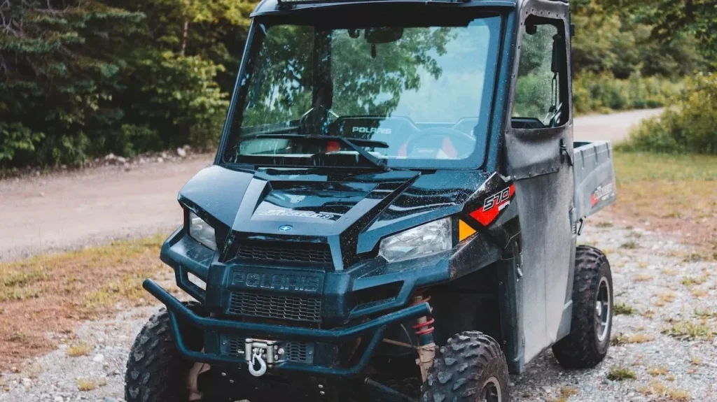 All-terrain vehicle on a gravel path in a lush forest, showcasing off-road capabilities